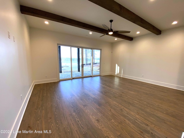 spare room featuring beam ceiling, dark hardwood / wood-style floors, and ceiling fan