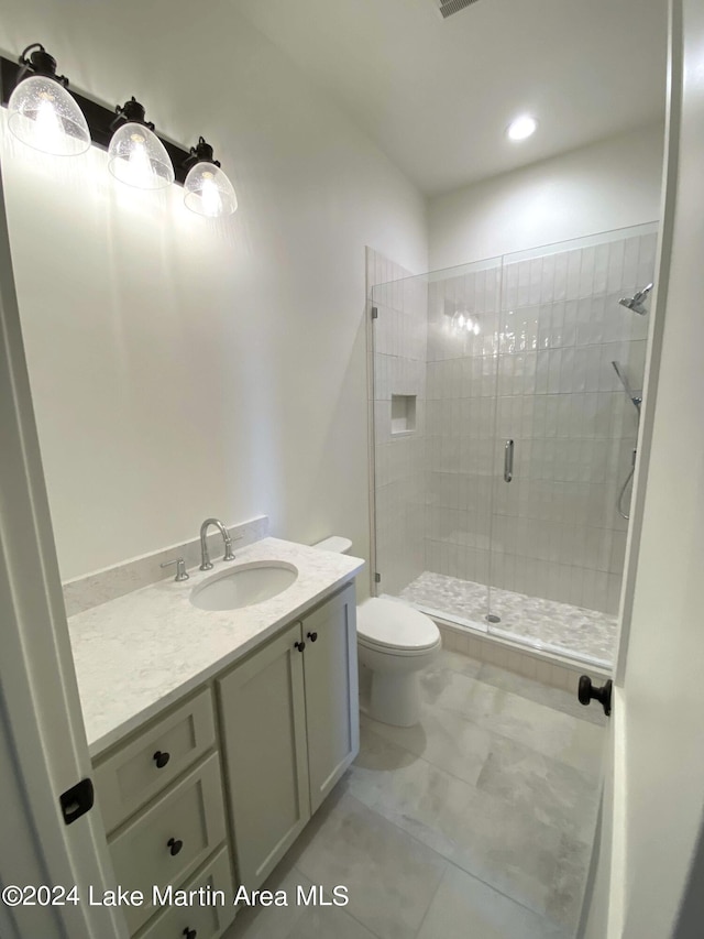 bathroom with vanity, toilet, and a shower with shower door