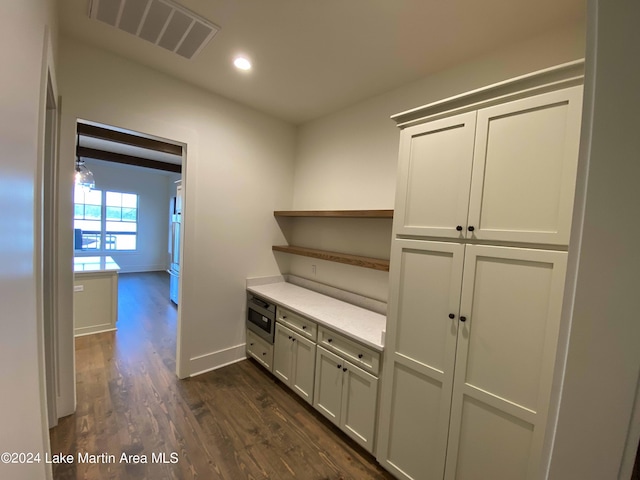 kitchen featuring white cabinetry, dark hardwood / wood-style floors, and stainless steel microwave