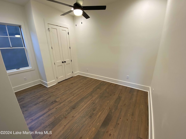 empty room featuring dark wood-type flooring and ceiling fan