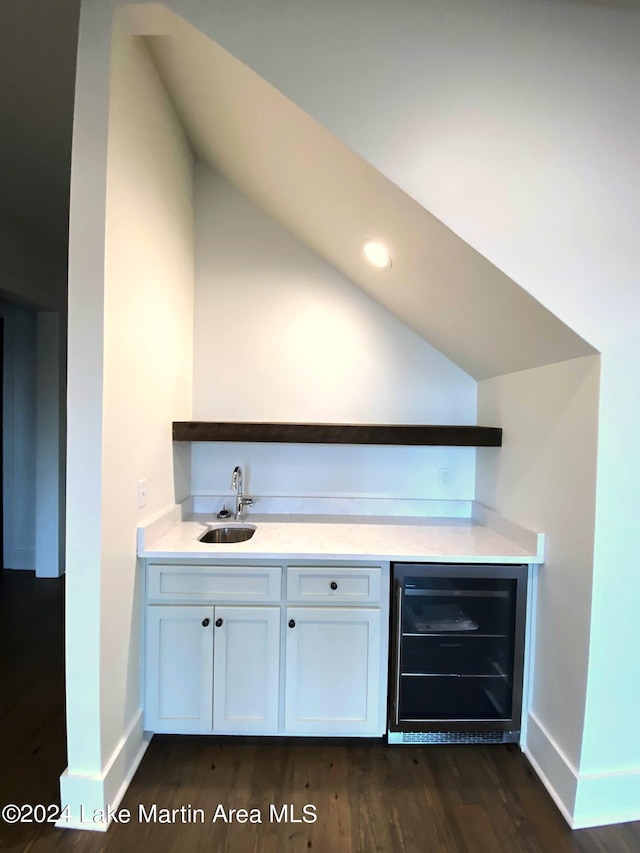 bar featuring dark hardwood / wood-style flooring, sink, beverage cooler, and white cabinets