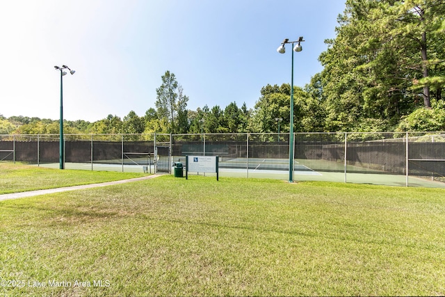 view of sport court with a yard and fence