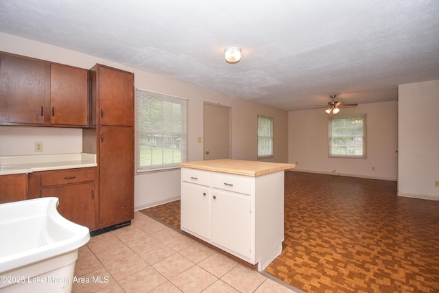 1330 Pearson Chapel Rd, Alexander City, AL 35010 - kitchen with a ceiling fan, light countertops, a kitchen island, white cabinetry, and brown cabinets