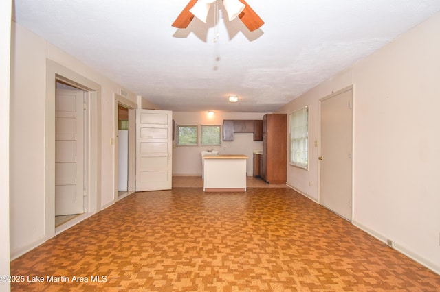 1330 Pearson Chapel Rd, Alexander City, AL 35010 - unfurnished living room featuring baseboards and a ceiling fan