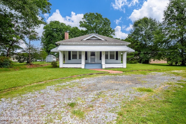 1330 Pearson Chapel Rd, Alexander City, AL 35010 - view of front of property featuring covered porch, a chimney, roof with shingles, and a front yard