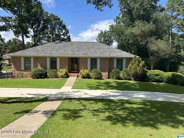 ranch-style house with brick siding and a front yard