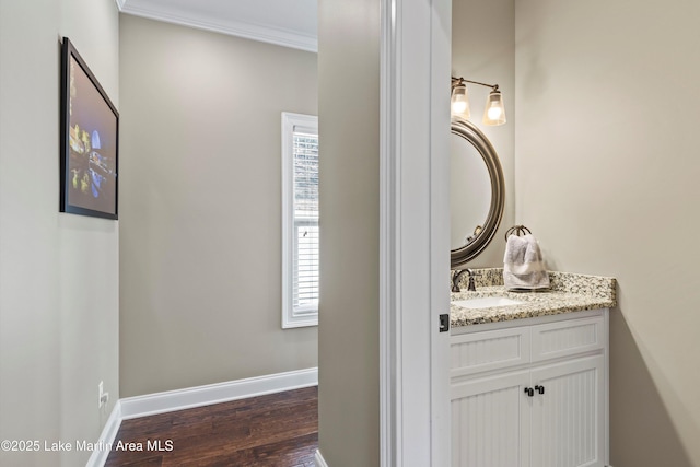 bathroom with hardwood / wood-style flooring, vanity, and crown molding