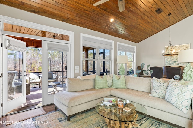 living room featuring wood ceiling, visible vents, and ceiling fan with notable chandelier