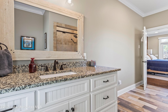 ensuite bathroom with ornamental molding, a shower stall, connected bathroom, and vanity