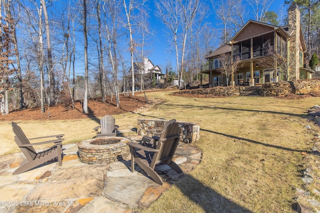 view of yard with a patio area, a balcony, and an outdoor fire pit