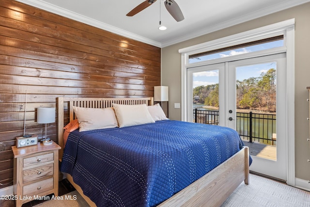 bedroom featuring french doors, ornamental molding, access to outside, ceiling fan, and wood walls