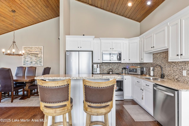 kitchen with appliances with stainless steel finishes, wood ceiling, sink, white cabinetry, and hanging light fixtures