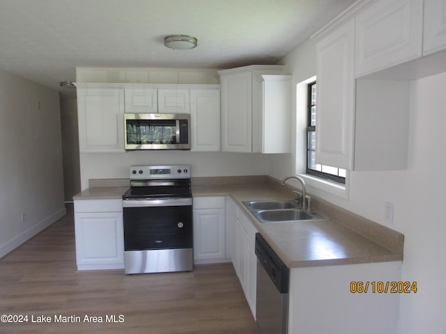 kitchen featuring white cabinets, sink, stainless steel appliances, and light hardwood / wood-style flooring