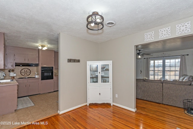 interior space with gray cabinets, sink, hardwood / wood-style floors, and black appliances