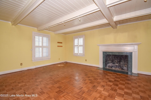 unfurnished living room with a healthy amount of sunlight, parquet flooring, a premium fireplace, and beamed ceiling