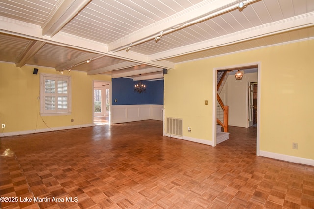 empty room with parquet floors, a notable chandelier, and beam ceiling