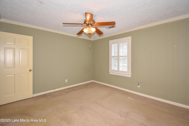 empty room featuring light colored carpet, a textured ceiling, ceiling fan, and ornamental molding