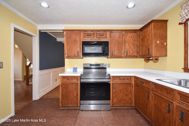 kitchen with dark tile patterned floors, sink, ornamental molding, stainless steel electric range oven, and a textured ceiling