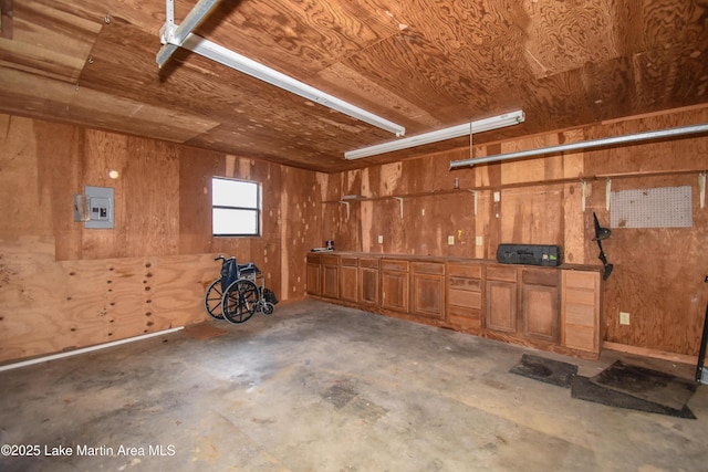 garage featuring electric panel, wooden walls, and wood ceiling