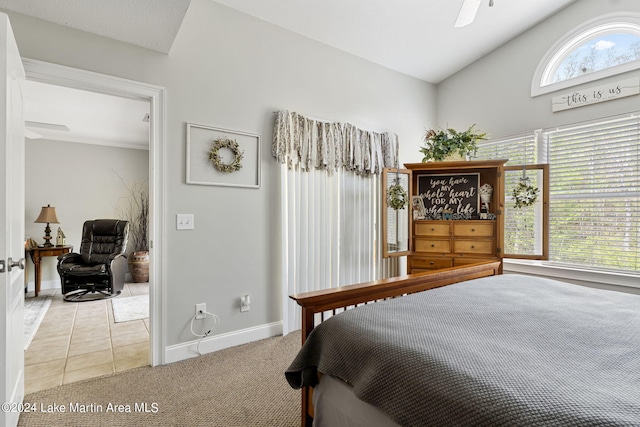 tiled bedroom with ceiling fan and lofted ceiling