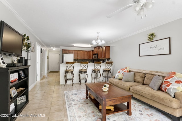 living room with light tile patterned flooring, ceiling fan with notable chandelier, and ornamental molding