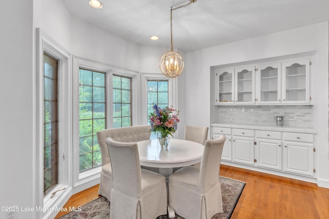 dining space with healthy amount of natural light, a chandelier, recessed lighting, and light wood finished floors