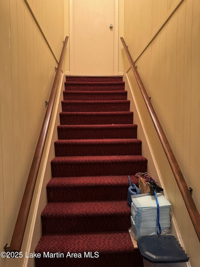 staircase with wood walls