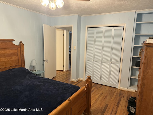 bedroom with crown molding, a closet, a textured ceiling, and light wood-type flooring