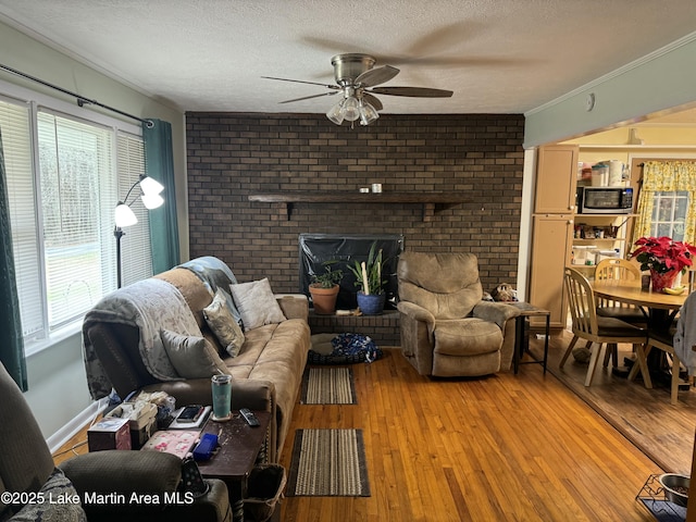 living room featuring wood-type flooring, a textured ceiling, plenty of natural light, and ceiling fan