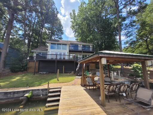 back of house featuring a lawn, a patio area, and a deck