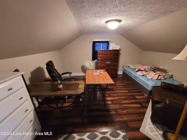 bedroom with a textured ceiling, dark wood-type flooring, and vaulted ceiling