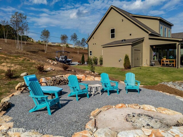 back of house with a lawn, a patio area, and an outdoor fire pit