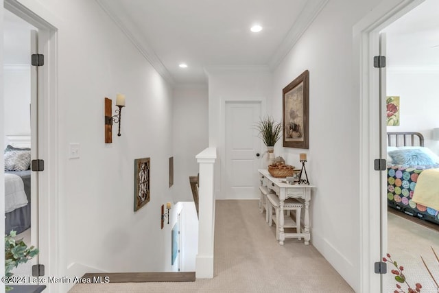 hall with light colored carpet and crown molding