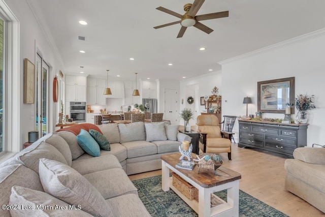 living room with ceiling fan, crown molding, and light hardwood / wood-style flooring