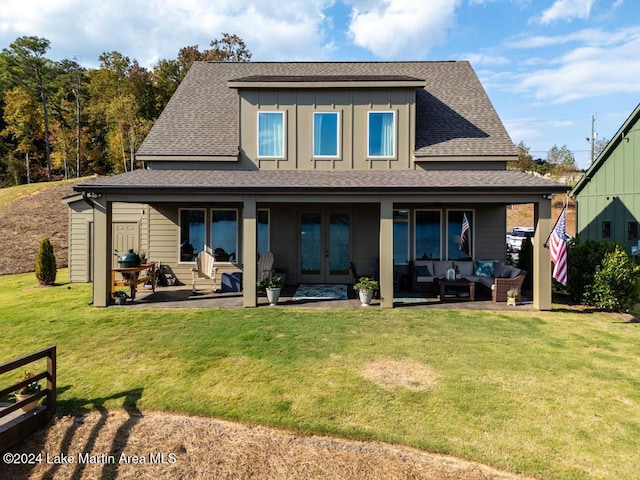 rear view of house featuring a lawn, an outdoor living space, a patio area, and french doors