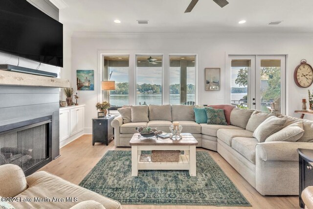 218 Williams Rd, Alexander City, AL 35010 - living room featuring a ceiling fan, a fireplace, crown molding, light wood-style floors, and a water view