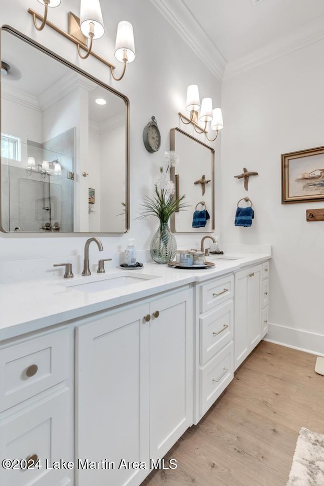 bathroom featuring a shower with door, vanity, wood-type flooring, and ornamental molding