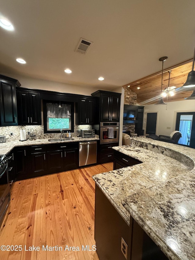 43 Shady Cv, Dadeville, AL 36853 - kitchen with dark cabinetry, appliances with stainless steel finishes, light stone counters, decorative backsplash, and recessed lighting