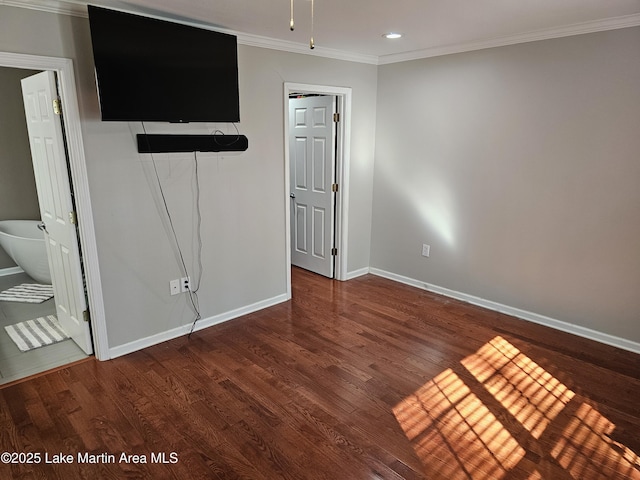 unfurnished bedroom with crown molding, connected bathroom, and wood-type flooring