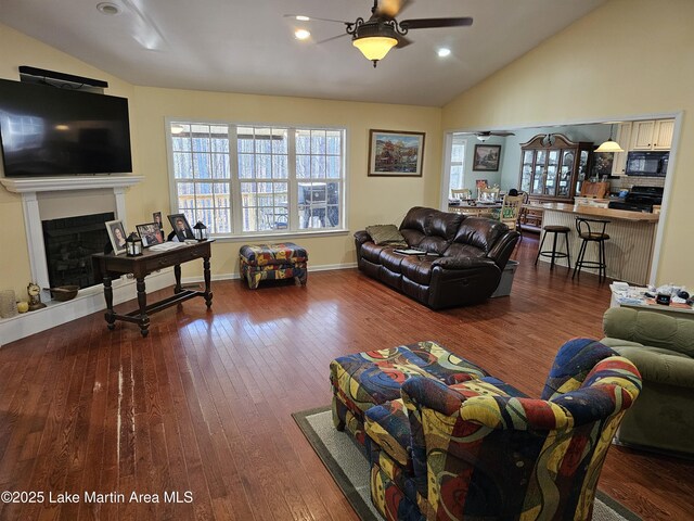 living room featuring dark wood-type flooring, lofted ceiling, and ceiling fan