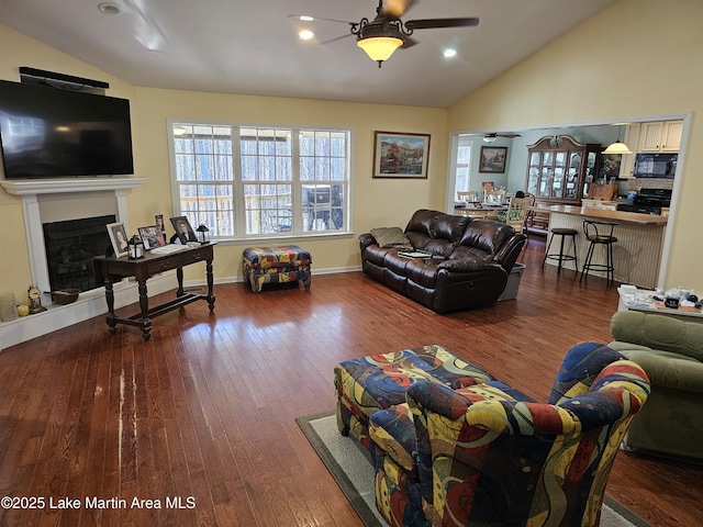 living room featuring ceiling fan, lofted ceiling, and hardwood / wood-style flooring