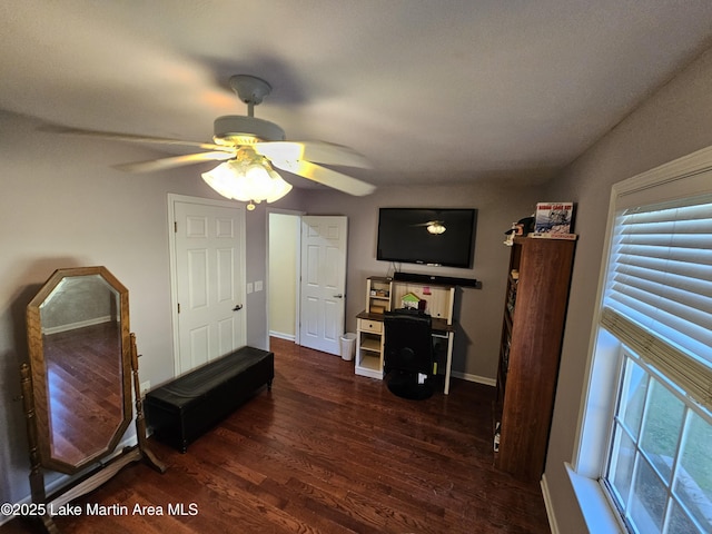 interior space featuring ceiling fan, dark wood-type flooring, and lofted ceiling