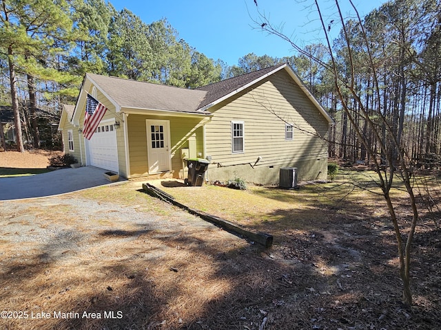 view of property exterior featuring cooling unit and a garage