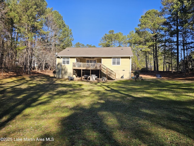 rear view of property featuring a lawn and a deck