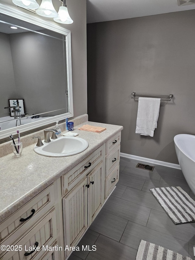 bathroom with vanity, a tub, and tile patterned floors