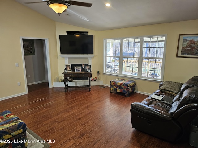 living room with ceiling fan, wood-type flooring, and vaulted ceiling