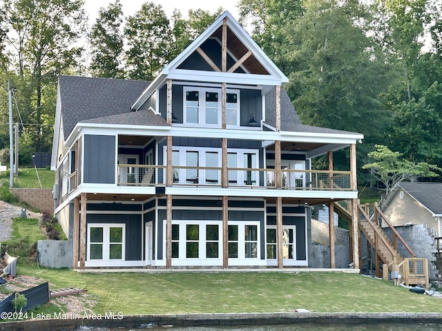 back of house featuring a balcony and a yard