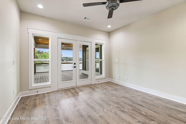 spare room with hardwood / wood-style flooring, ceiling fan, and french doors