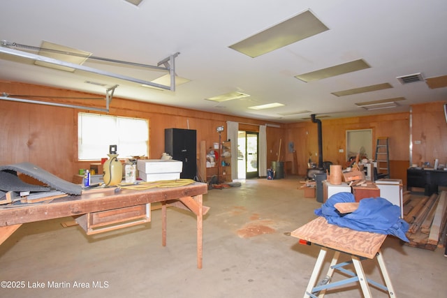 405 4th St, Tallassee, AL 36078 - miscellaneous room featuring wood walls, healthy amount of natural light, concrete floors, and a wood stove