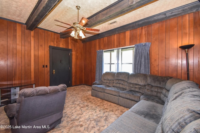405 4th St, Tallassee, AL 36078 - living area featuring beam ceiling, wood walls, carpet, and ceiling fan